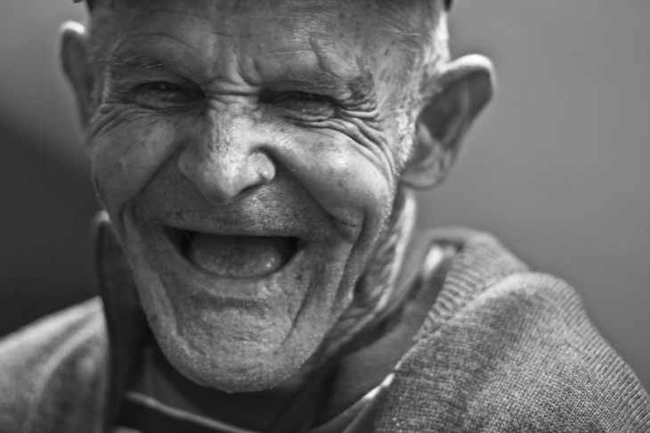 grayscale photo of laughing old man